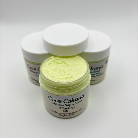 several Jars of 'Coco Cabana' whipped sugar scrub on a white background with holographic labels handcrafted by the blooming butterfly company