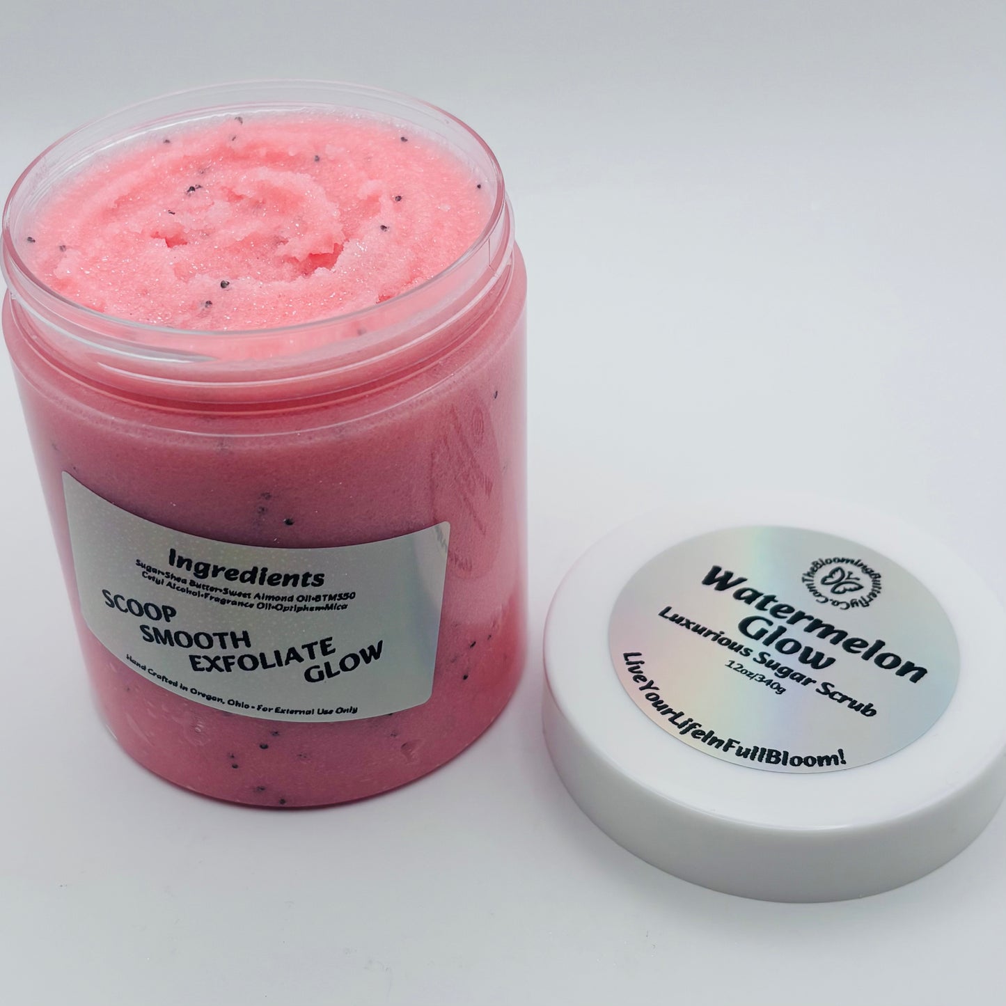 Pink watermelon glow sugar scrub jar with a holographic label on a white background handcrafted by the blooming butterfly company