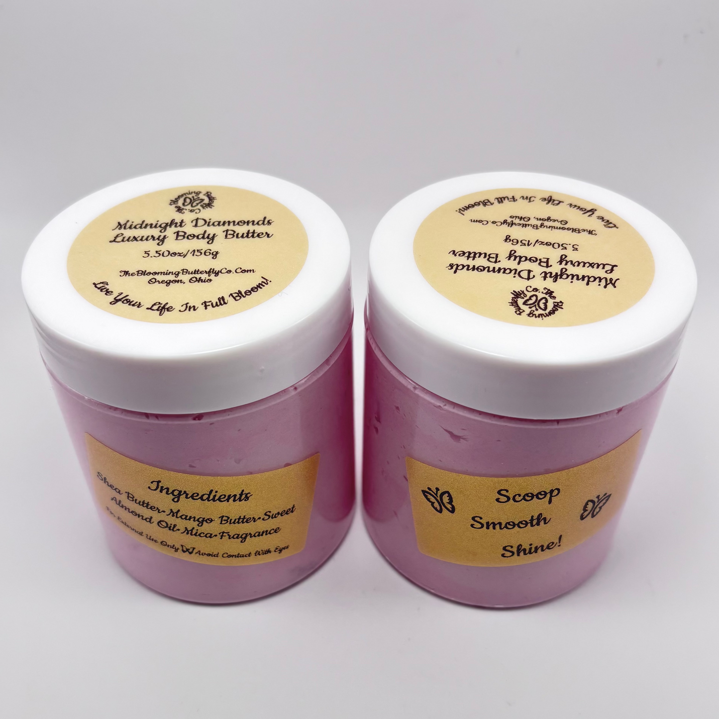 Two jars of midnight diamonds luxury body butter with gold, holographic labels and magenta colored Mica with white lids handcrafted by the blooming butterfly company