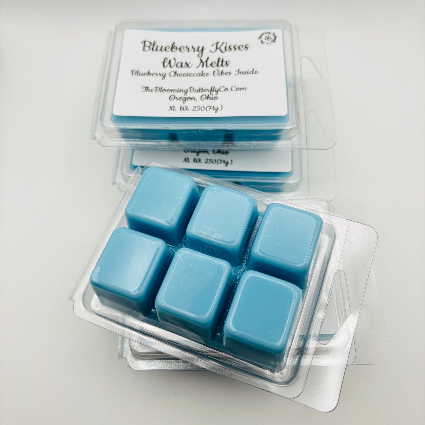 Blueberry kisses wax melts scented in blueberry cheesecake fragrance, colored blue shimmer in a six clam shell mold photo on a white background, handcrafted by the blooming butterfly