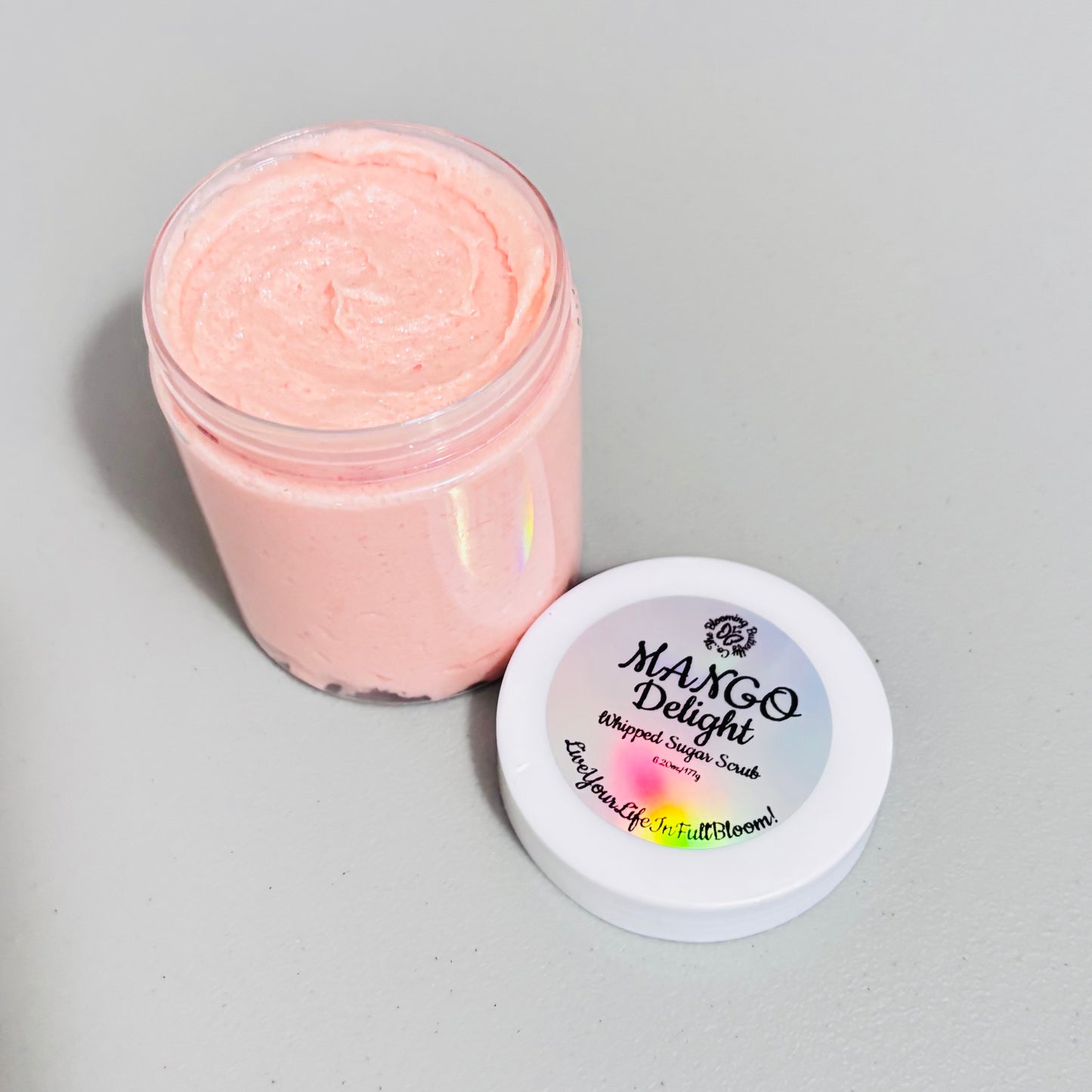 Clear jar of mango delight, whipped sugar scrub with white lid and holographic label handcrafted by the blooming butterfly company