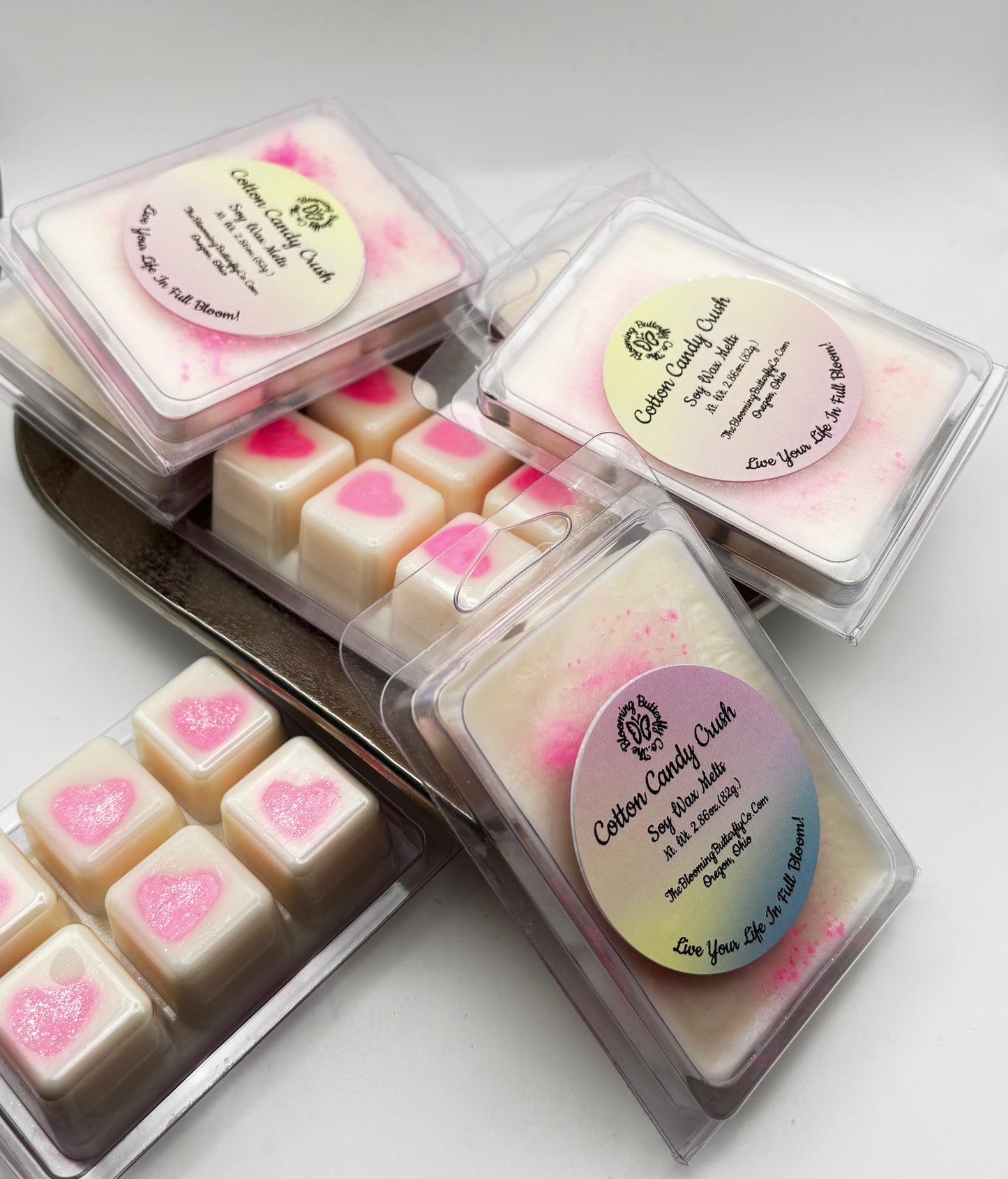 cotton candy wax melts in clam shell containers with bright pink heart in the middle of shimmering white wax with sparkles by the blooming butterfly company