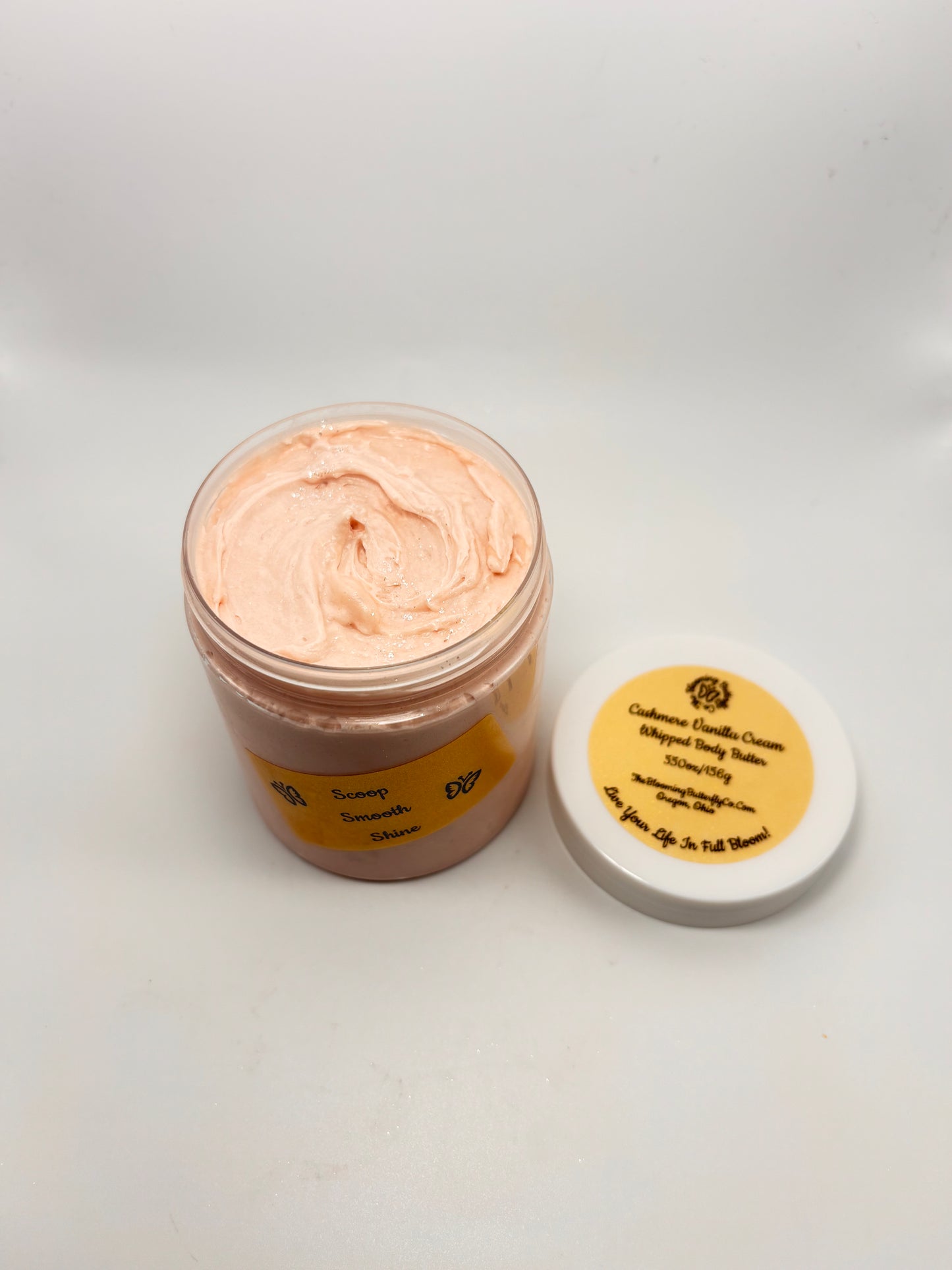 Jar of Cashmere Vanilla Cream luxury body butter with white lid and gold holographic label with shimmering sparkles on top handcrafted by the blooming butterfly Company