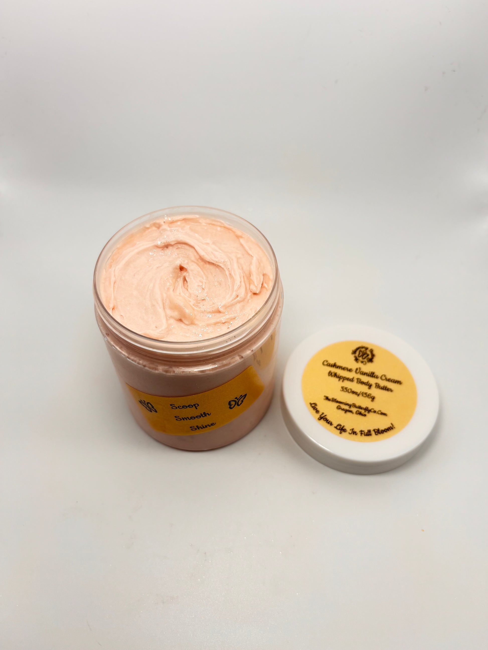 Jar of Cashmere Vanilla Cream luxury body butter with white lid and gold holographic label with shimmering sparkles on top handcrafted by the blooming butterfly Company