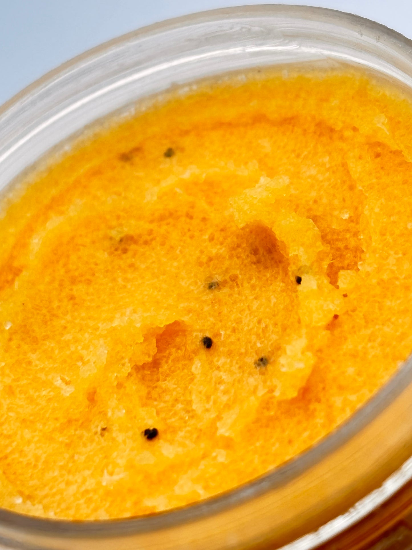 close up of orange creamsicle sugar scrub with poppy seeds