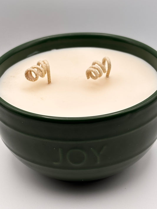 mountain pine candle in a decorative holiday vessel says joy