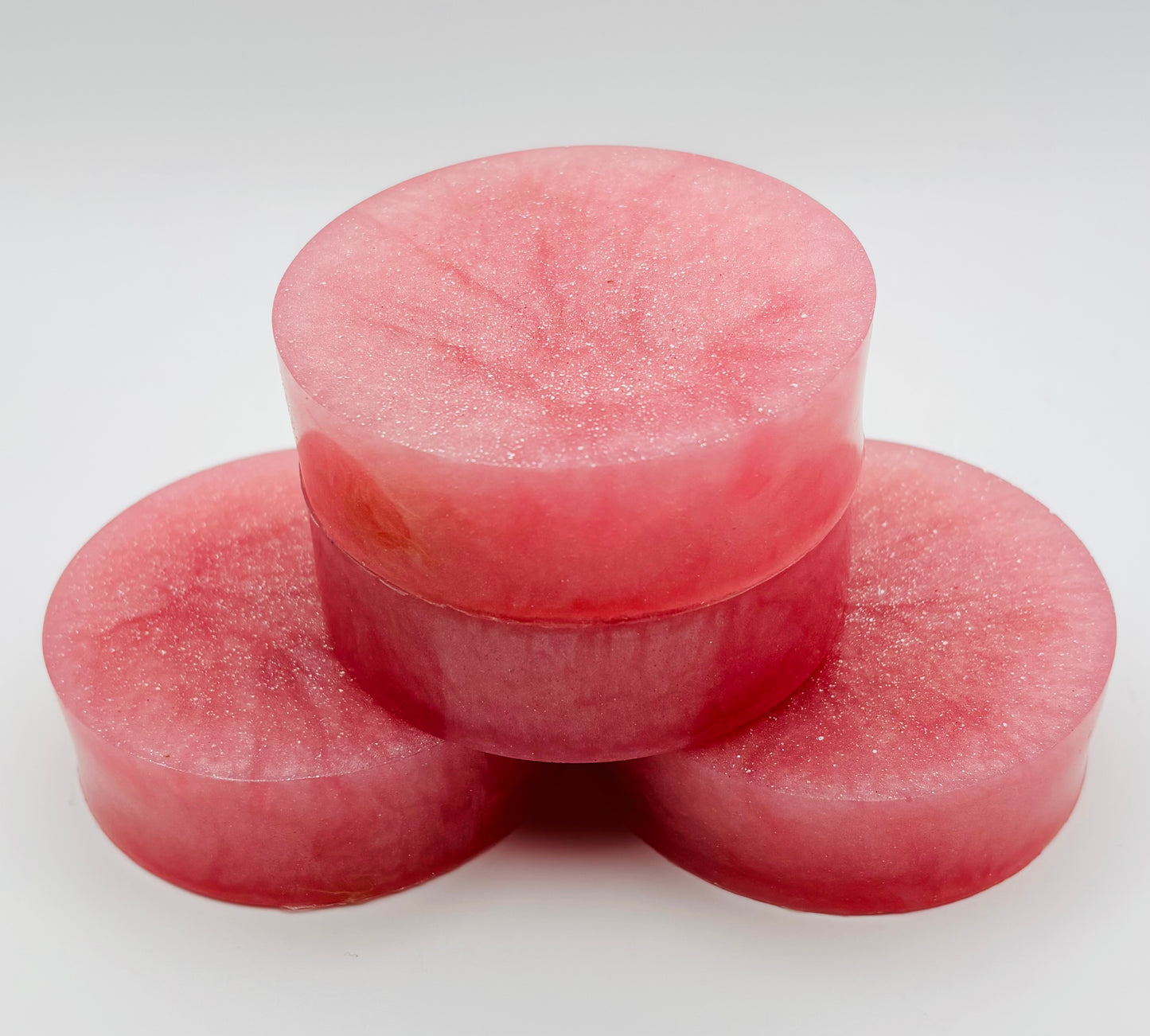 close up view of a stack of pink sparkling grapefruit loofah soap bars infused with organically grown loofahs by the blooming butterfly company