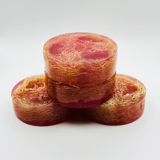 a stack of handmade loofah soap bars infused with a thousand wishes fragrance oil, shimmering magenta colored mica and organically grown loofahs