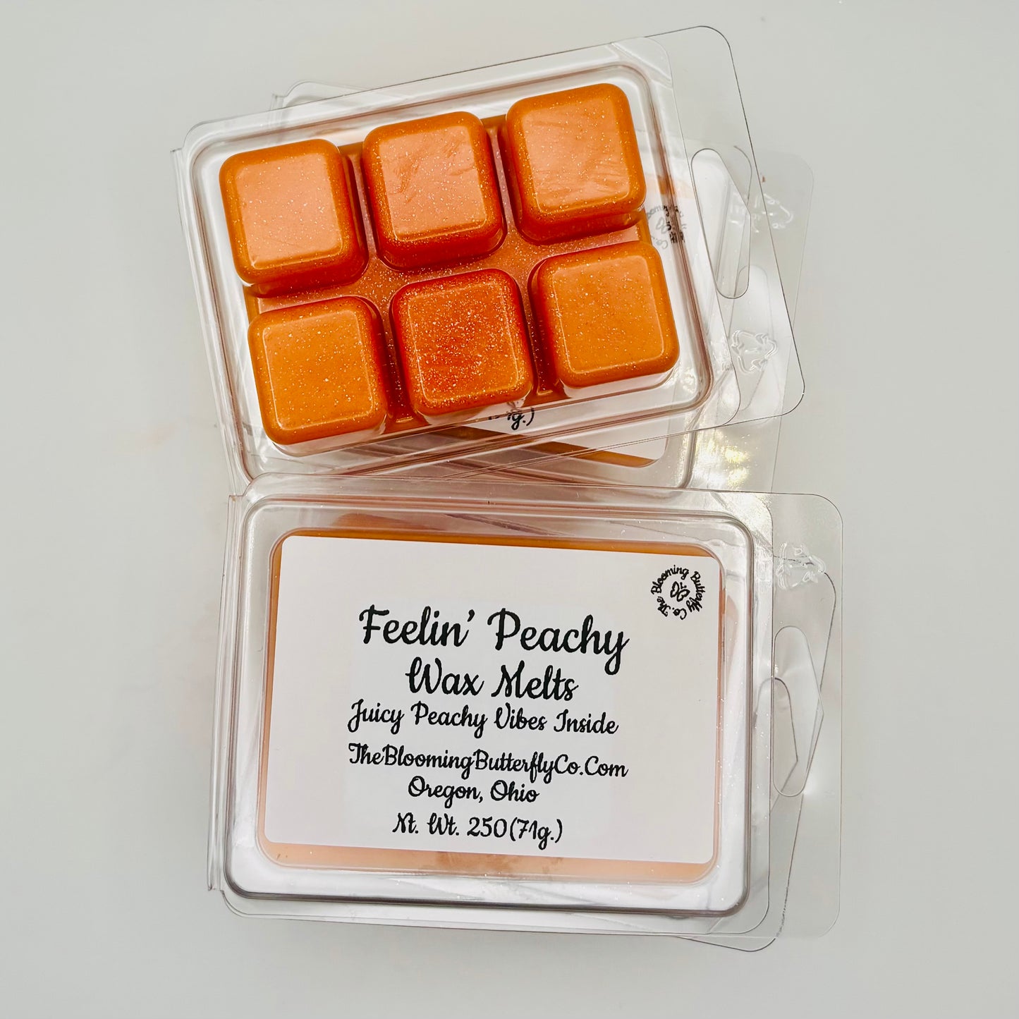 shimmering orange peach scented wax melts in a 6 count clam shell with label made by the blooming butterfly company