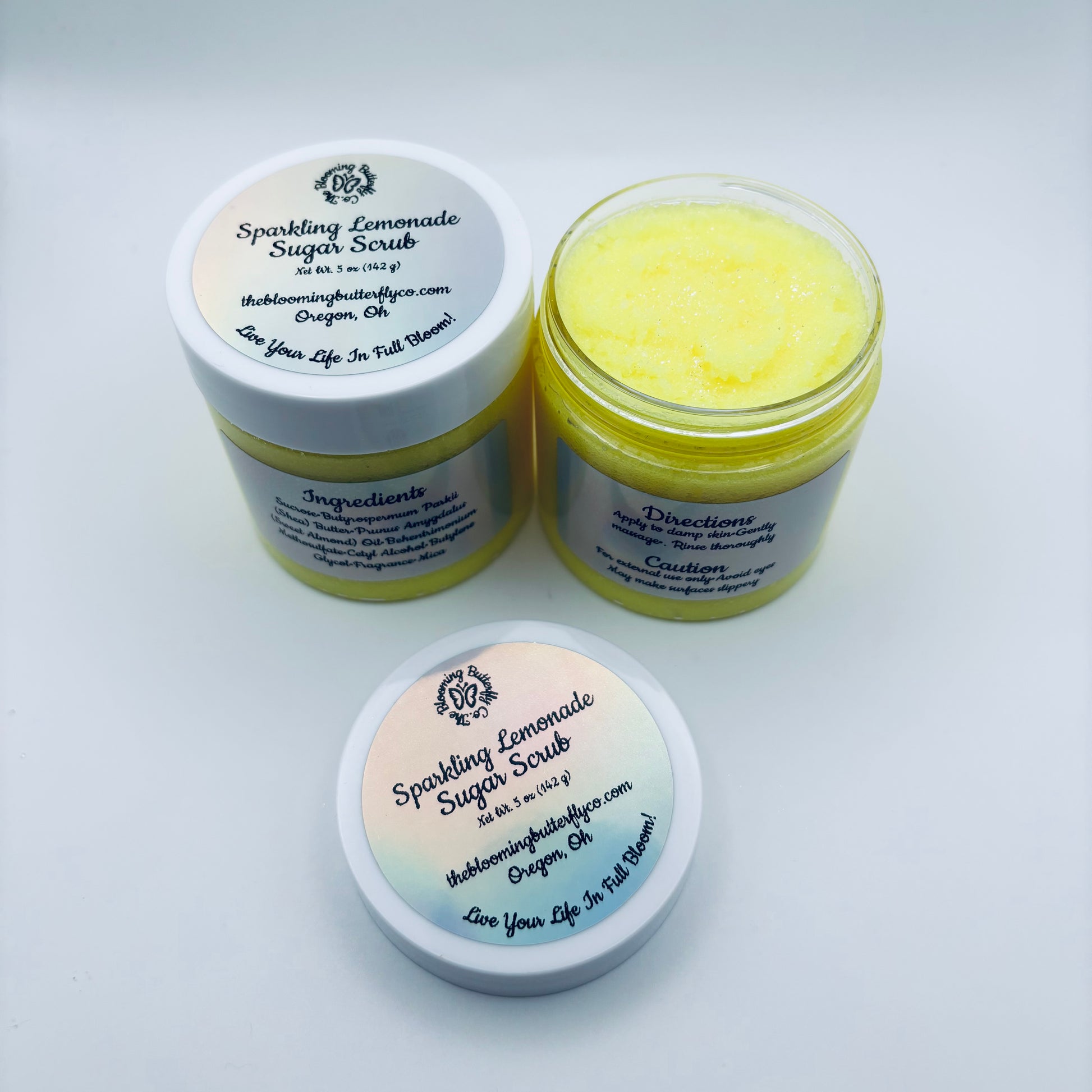 Two jars of Sparkling Lemonade Sugar Scrub on a white background handcrafted by the blooming butterfly company