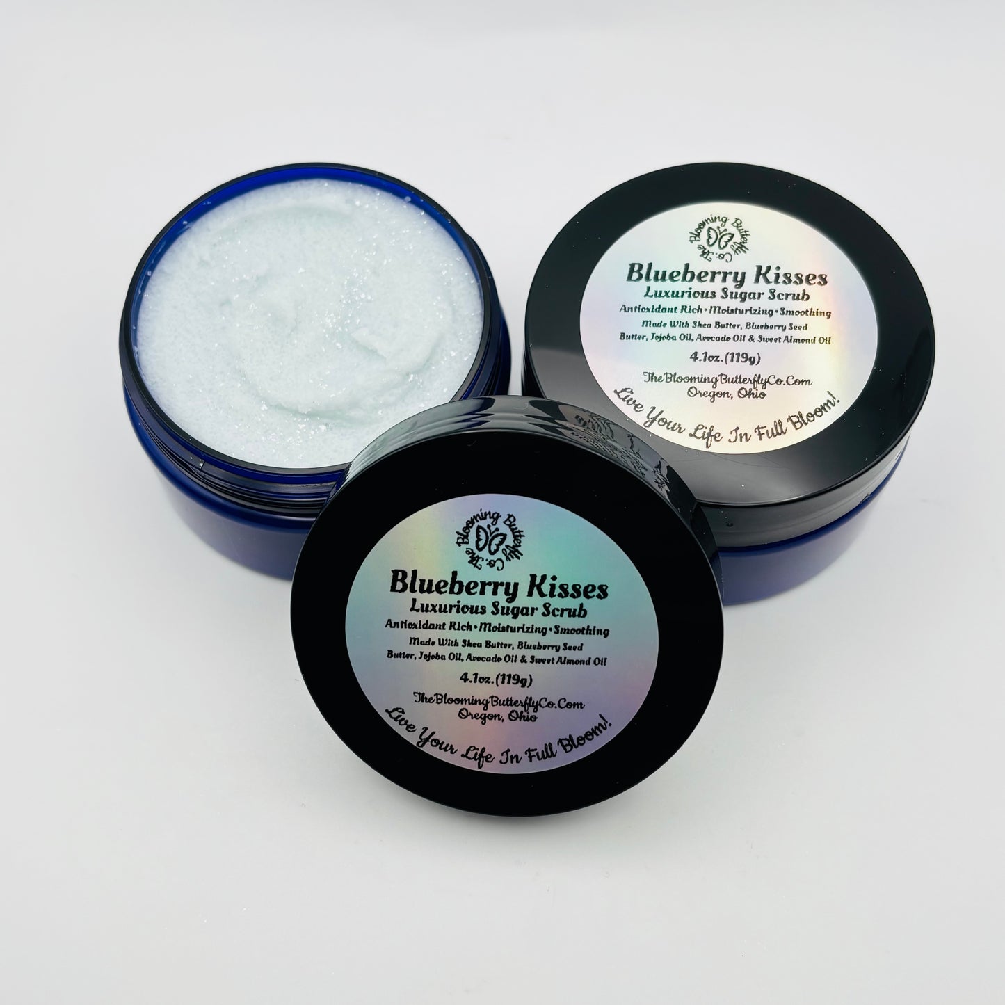 Blueberry Kisses luxurious sugar scrub in open jar with lid on a white background handcrafted by the blooming butterfly company