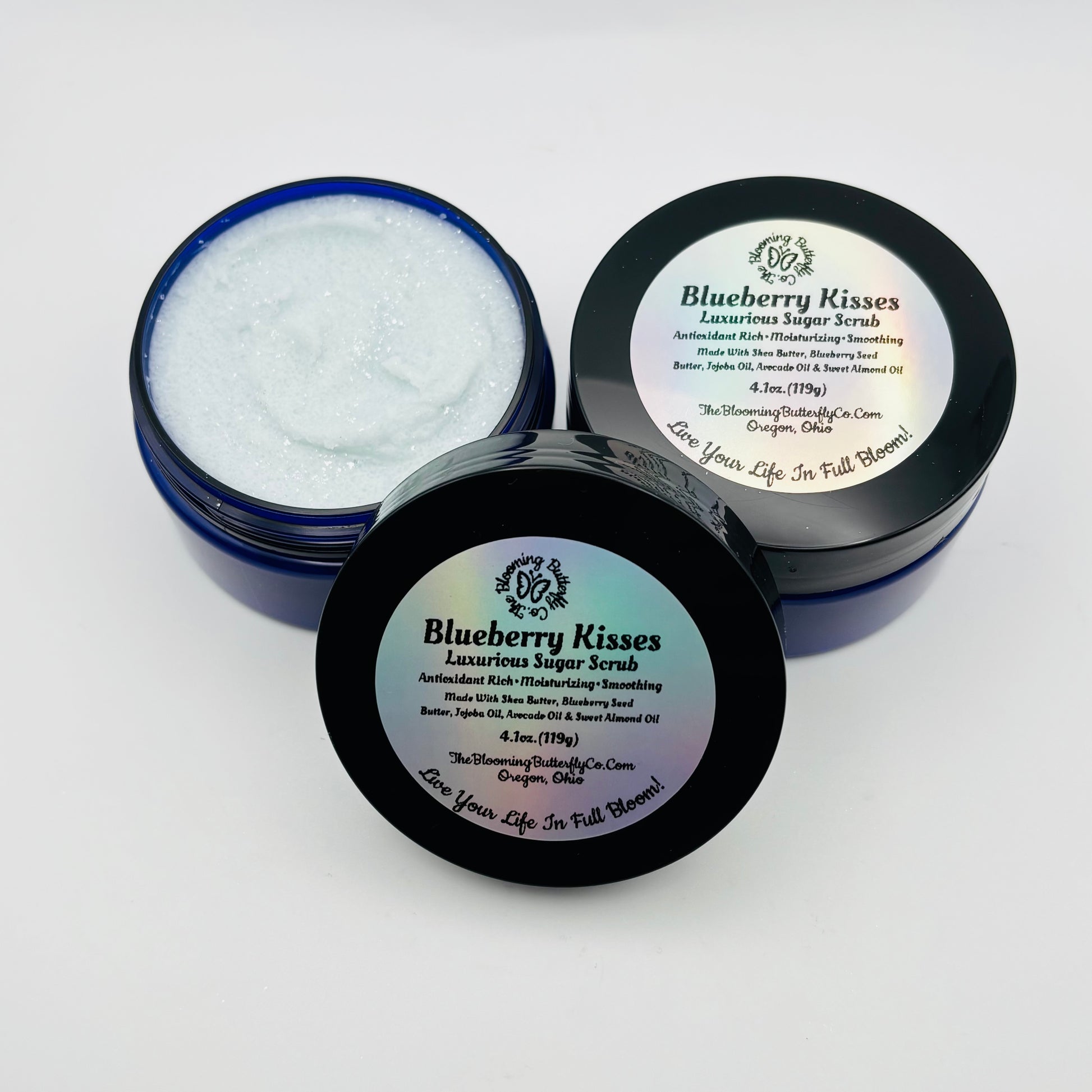 Blueberry Kisses luxurious sugar scrub in open jar with lid on a white background handcrafted by the blooming butterfly company