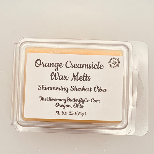 Orange Creamsicle wax melts packaging with label on a light gray background handcrafted by the blooming butterfly Company