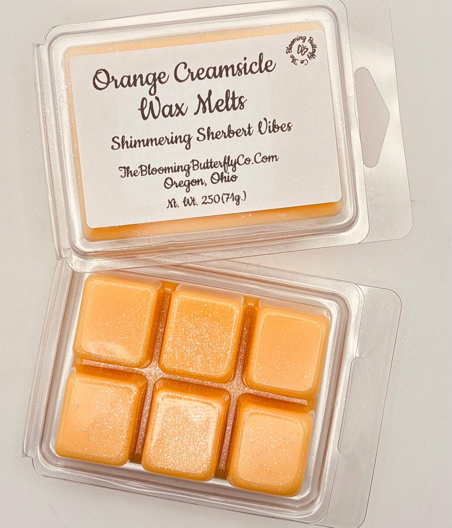 Orange creamsicle wax melts in a clear packaging handcrafted by the blooming butterfly company