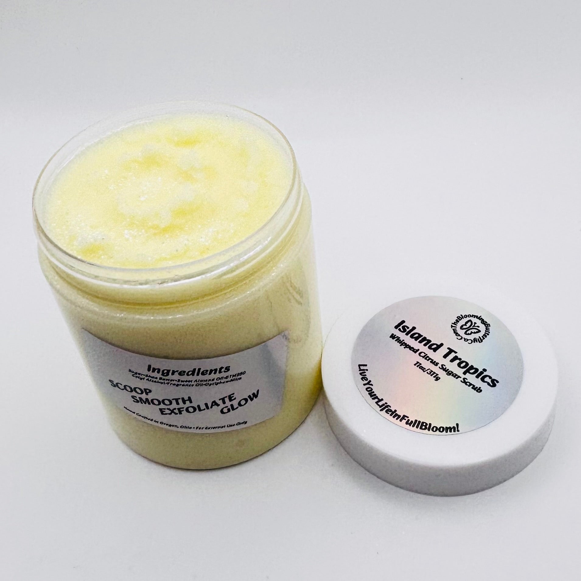 Jar of Island Tropics body scrub with a white lid and holographic label hand crafted by the blooming butterfly company